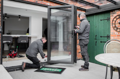 A photo of one of our engineers opening the door on one of a group of The Window Doctor vans